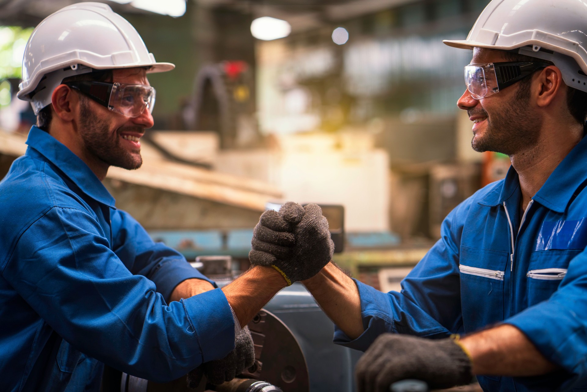 Engineers and technicians join hands to work together. Engineers safety vests and hardhats making deal and shaking hands together for success.